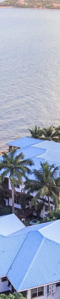 An aerial of the resort and its blue-roofed villas seen from over the sea