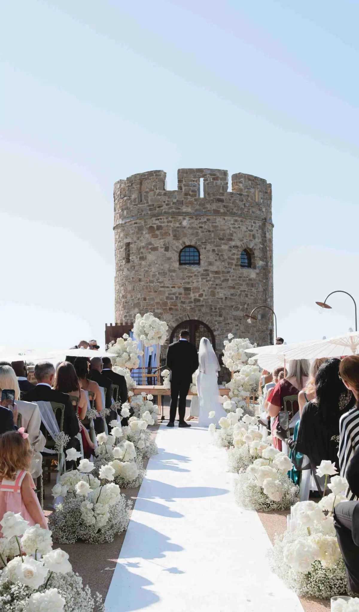 The aisle at Castello di Rocca Cilento, white parasols up, the round tower straight ahead