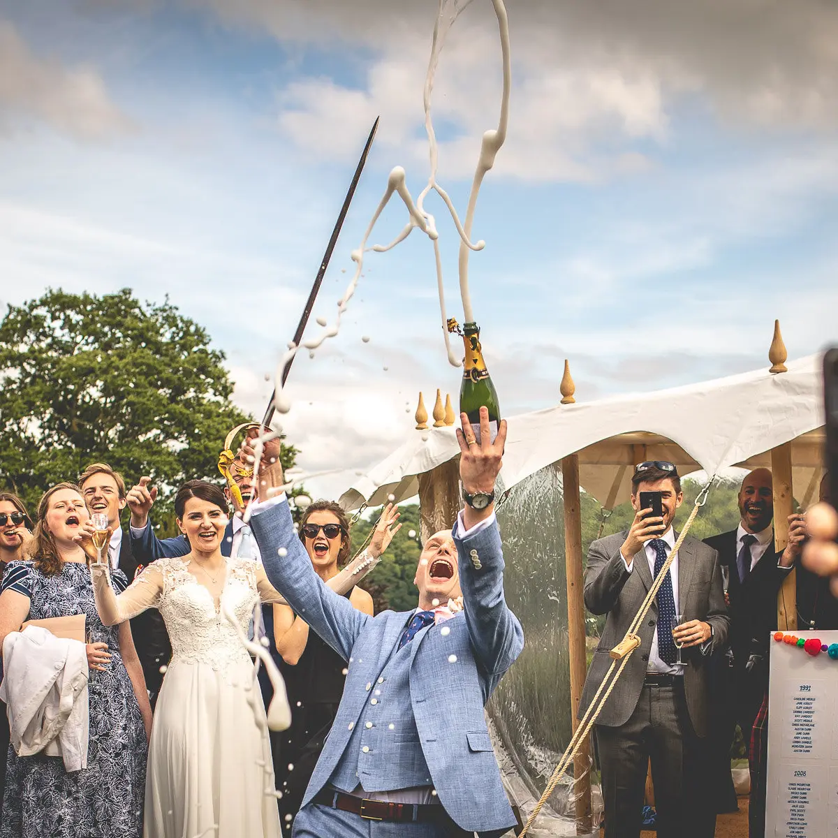 A champagne toast in the marquee, guests cheering