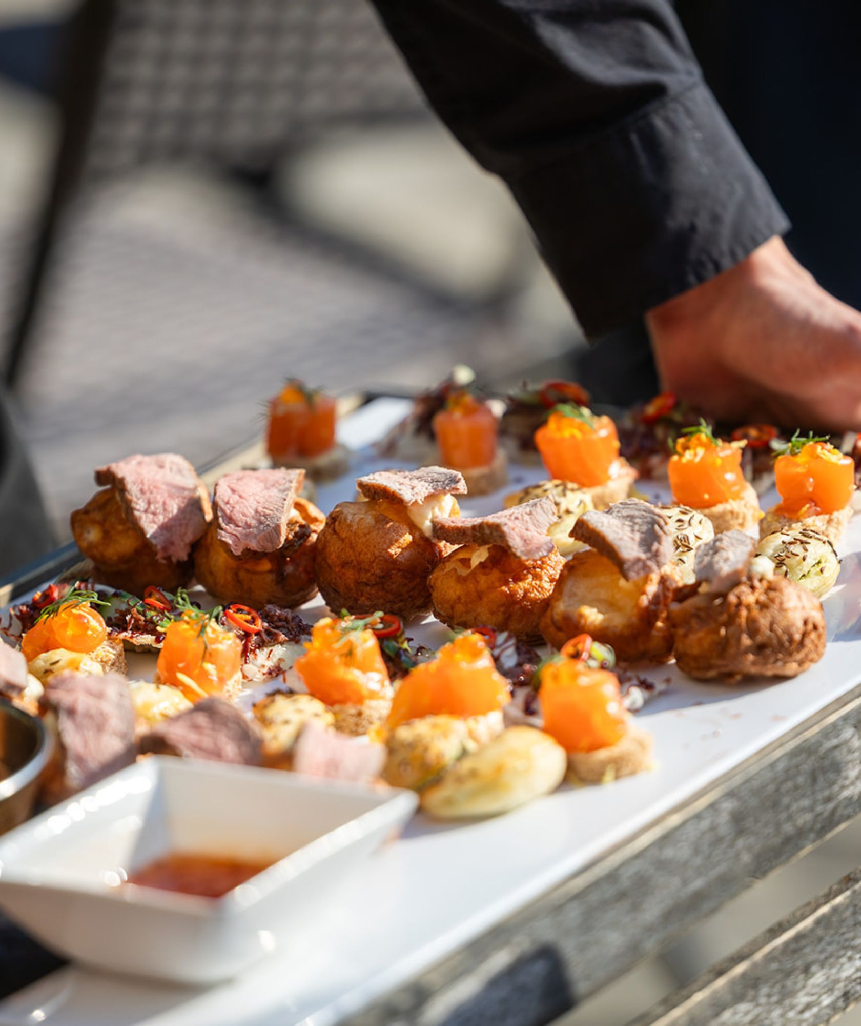 Canapés being plated, delicate smoked-salmon bites on a serving tray