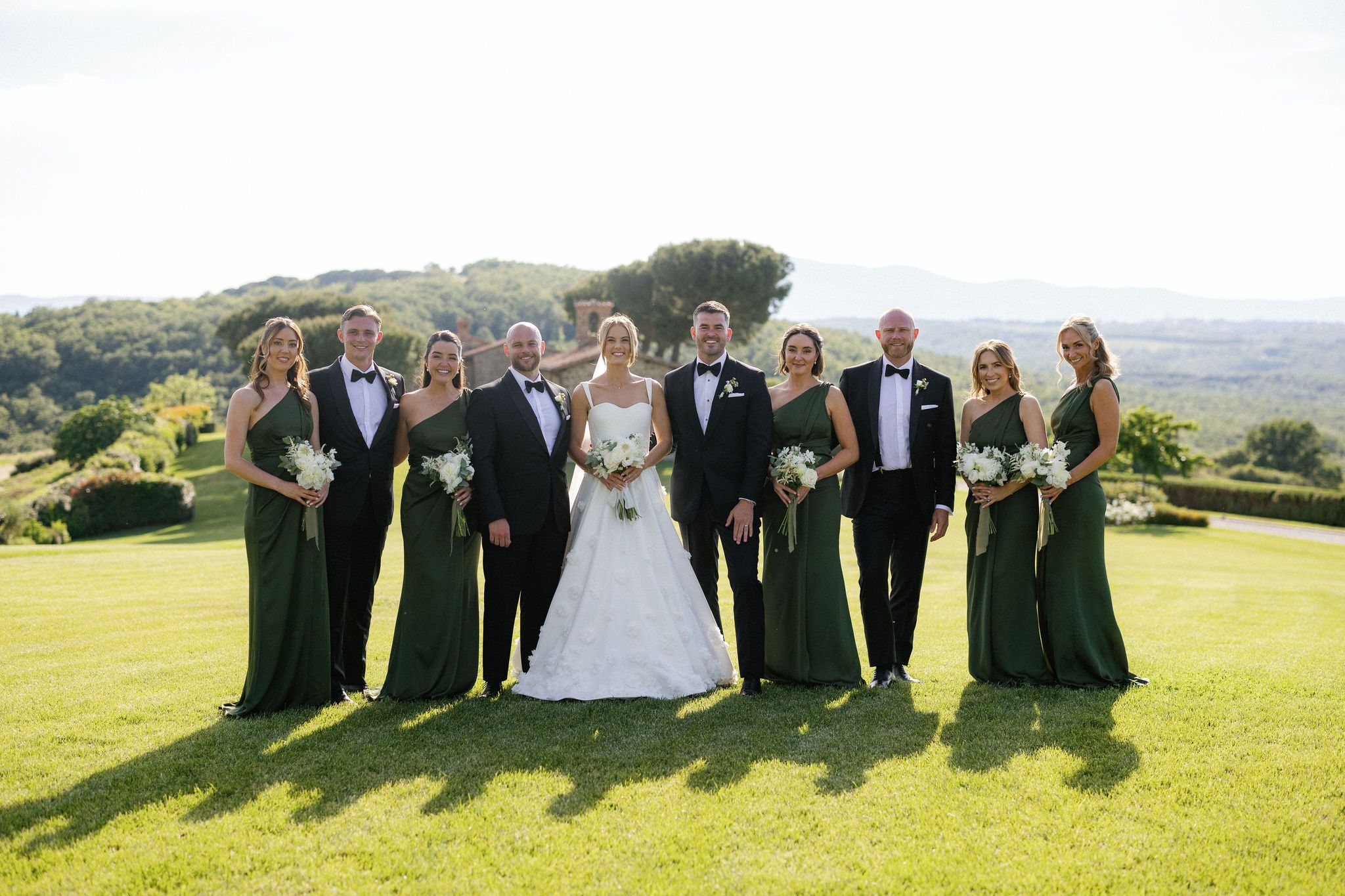 The wedding party on a lawn above the valley, the bridesmaids in dark green