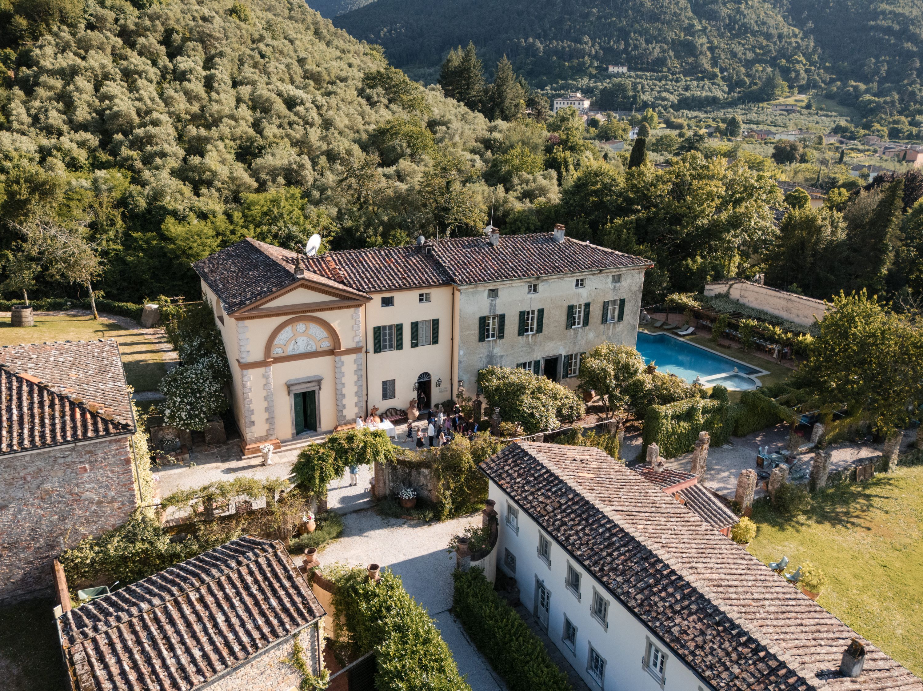 Aerial view of Villa Michaela above Lucca, surrounded by olive groves and pine-clad hills, Tuscany