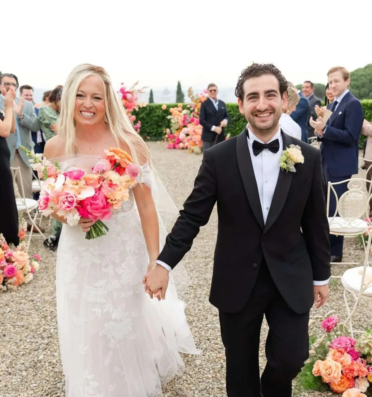 Walking back through applauding guests, coral flowers banked on the gravel