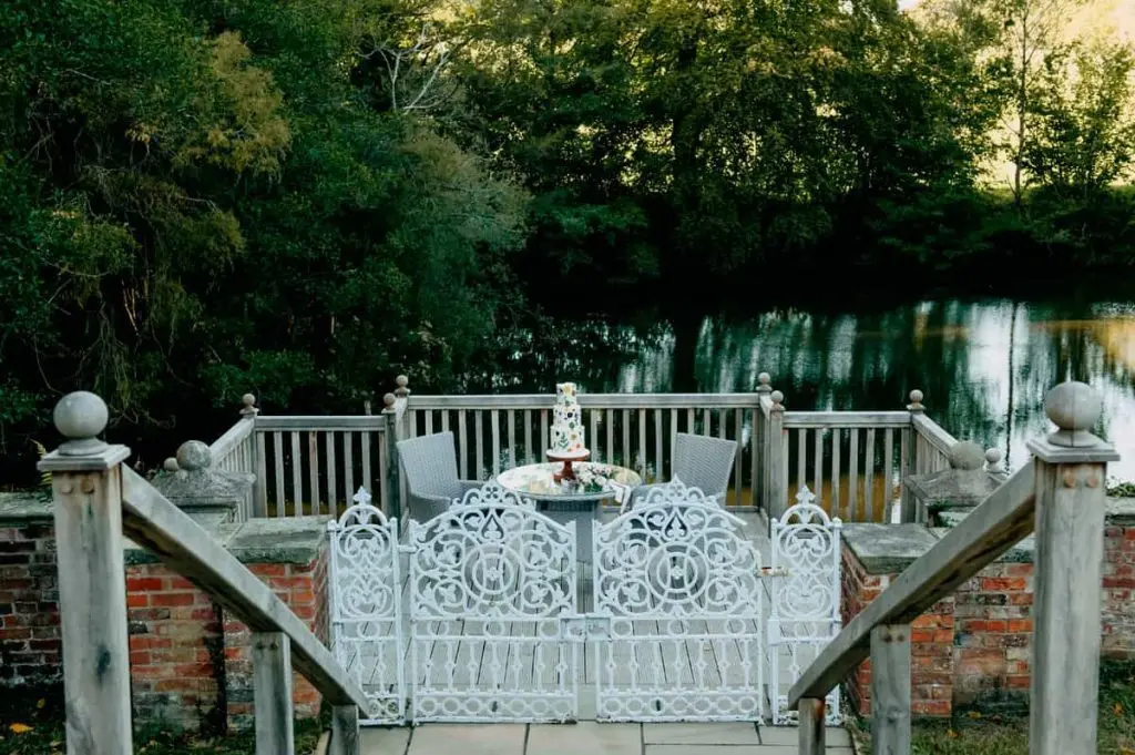 An outdoor reception table with a cake and a sweeping countryside view