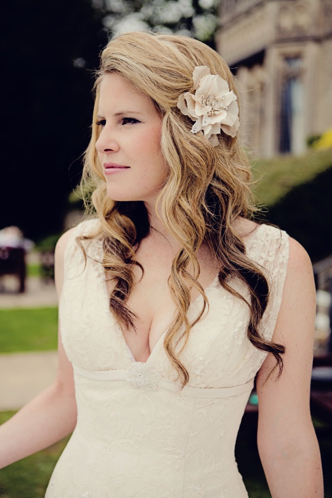 A close bridal portrait, loose waved hair and a flower hair accessory