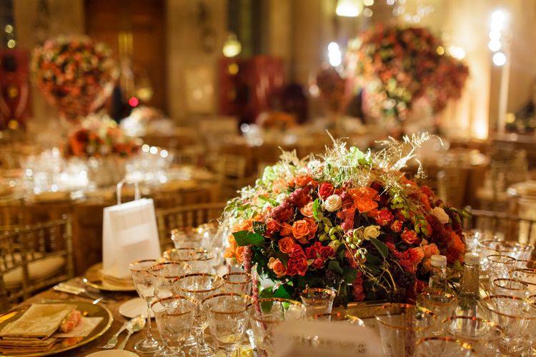 A candlelit reception, an orange and red centrepiece at its heart