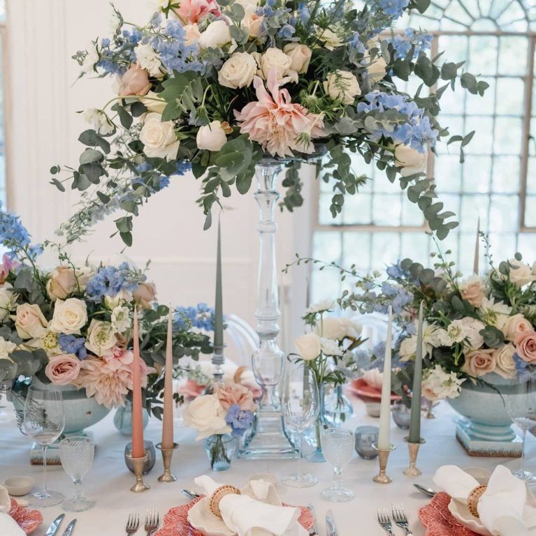A tablescape of blue delphinium and coral
