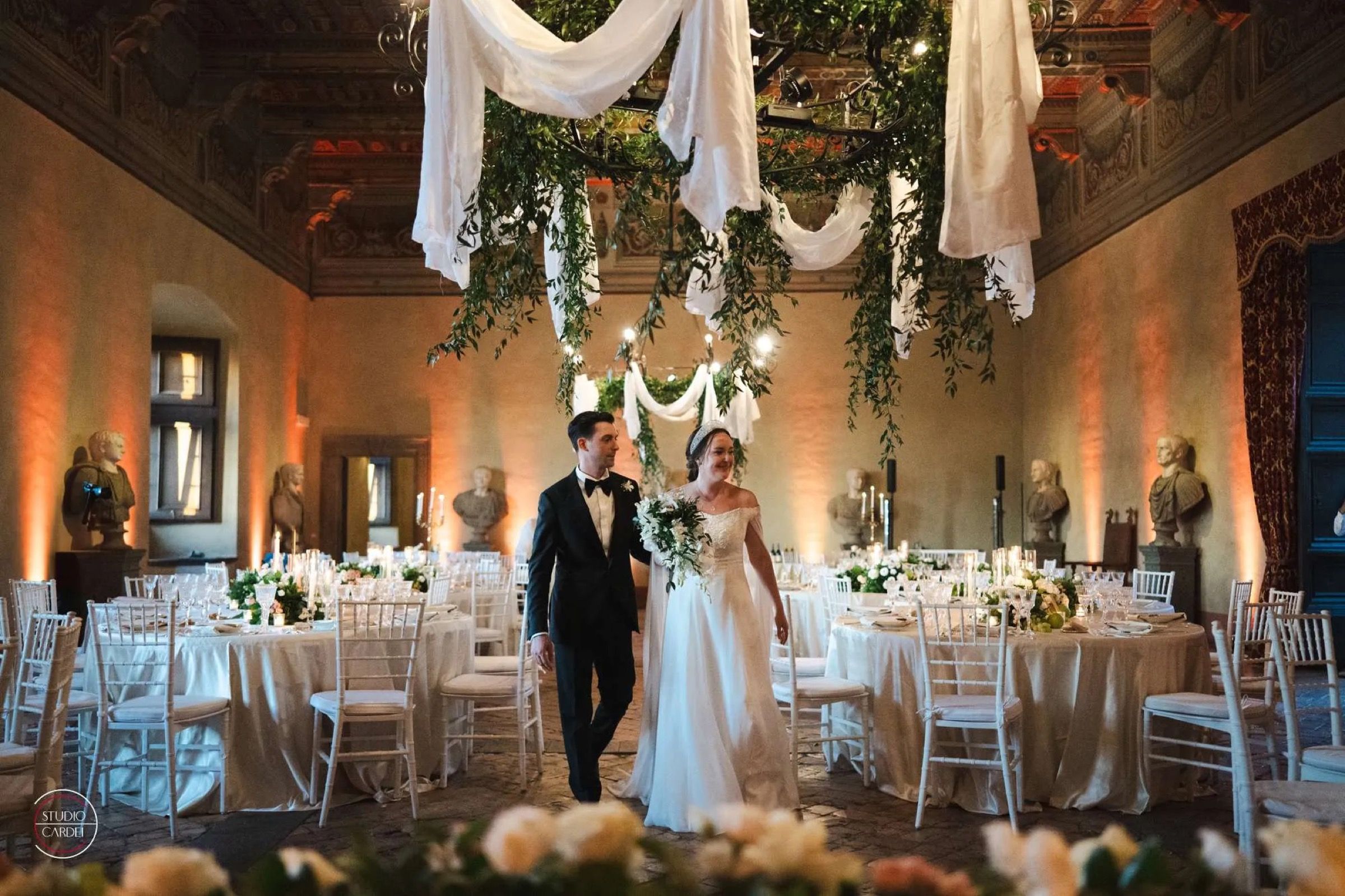 A reception under a draped canopy, in the evening