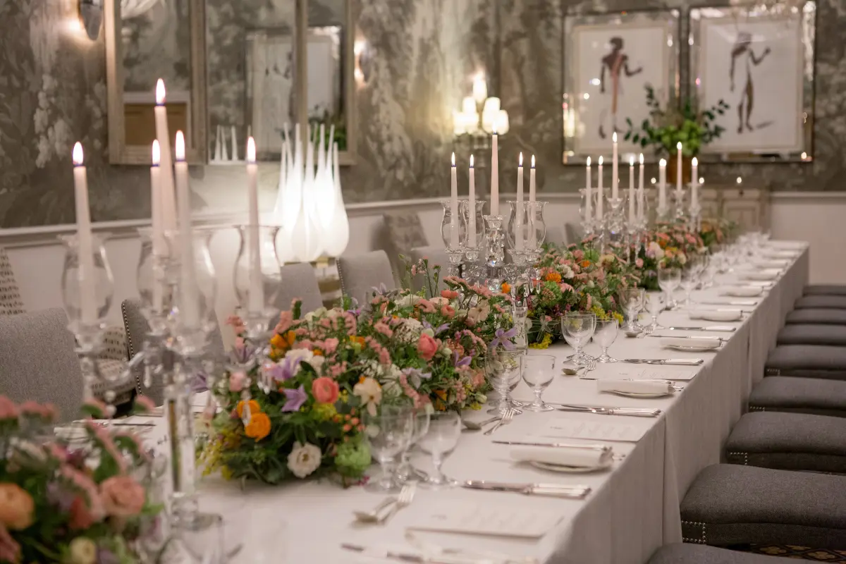 The Shooting Gallery, a long table dressed with colourful flowers and candelabra, Haymarket Hotel, London, England