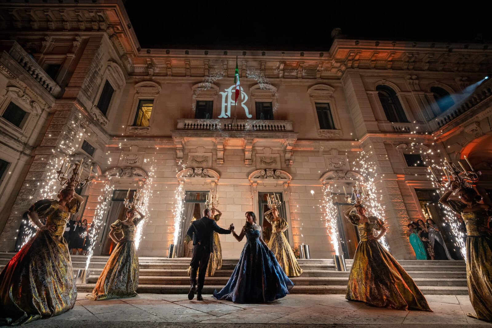 The same couple on the palazzo steps as the sparkler fountains burn down around them