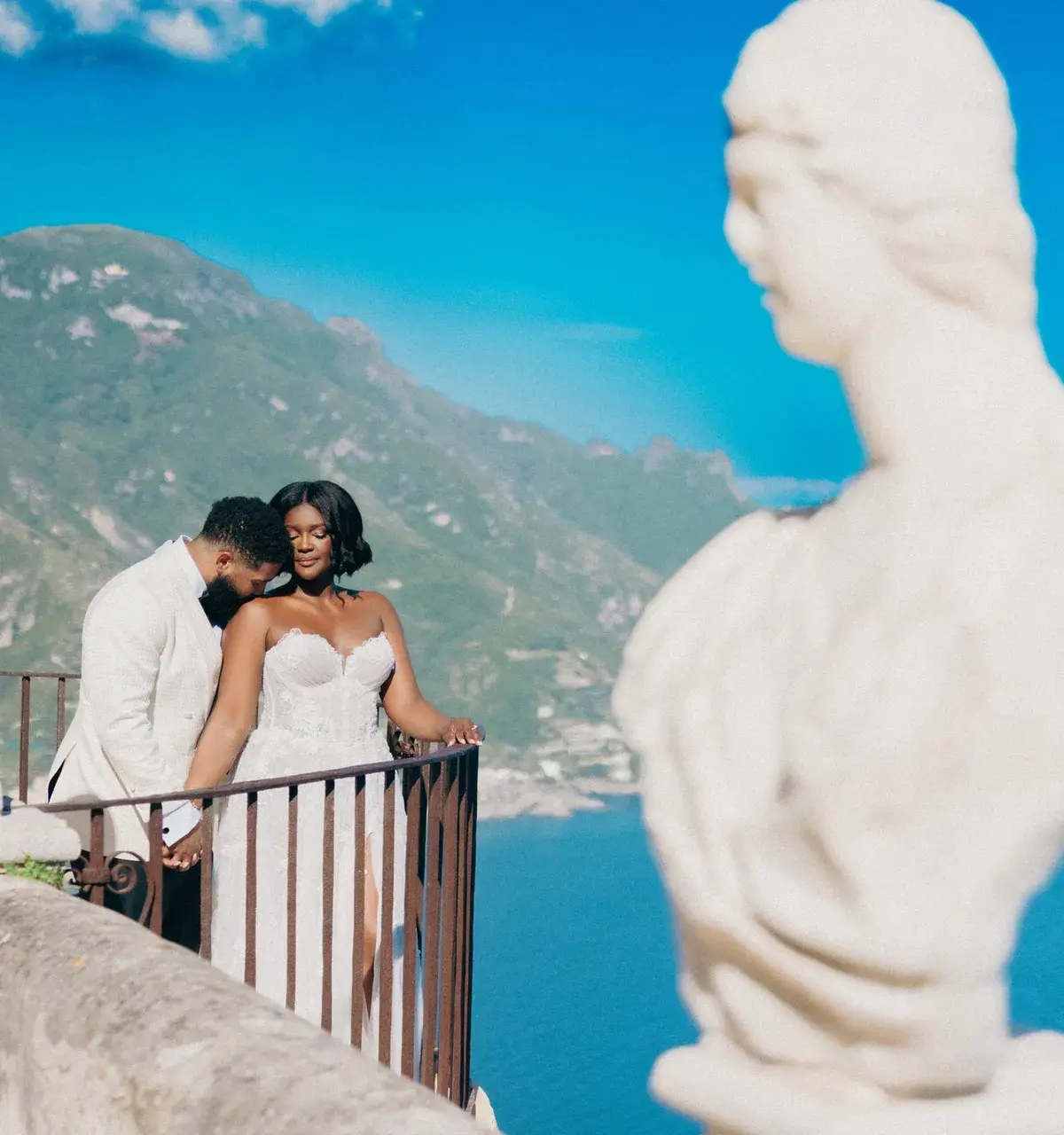 The couple between two marble busts on a belvedere above the water