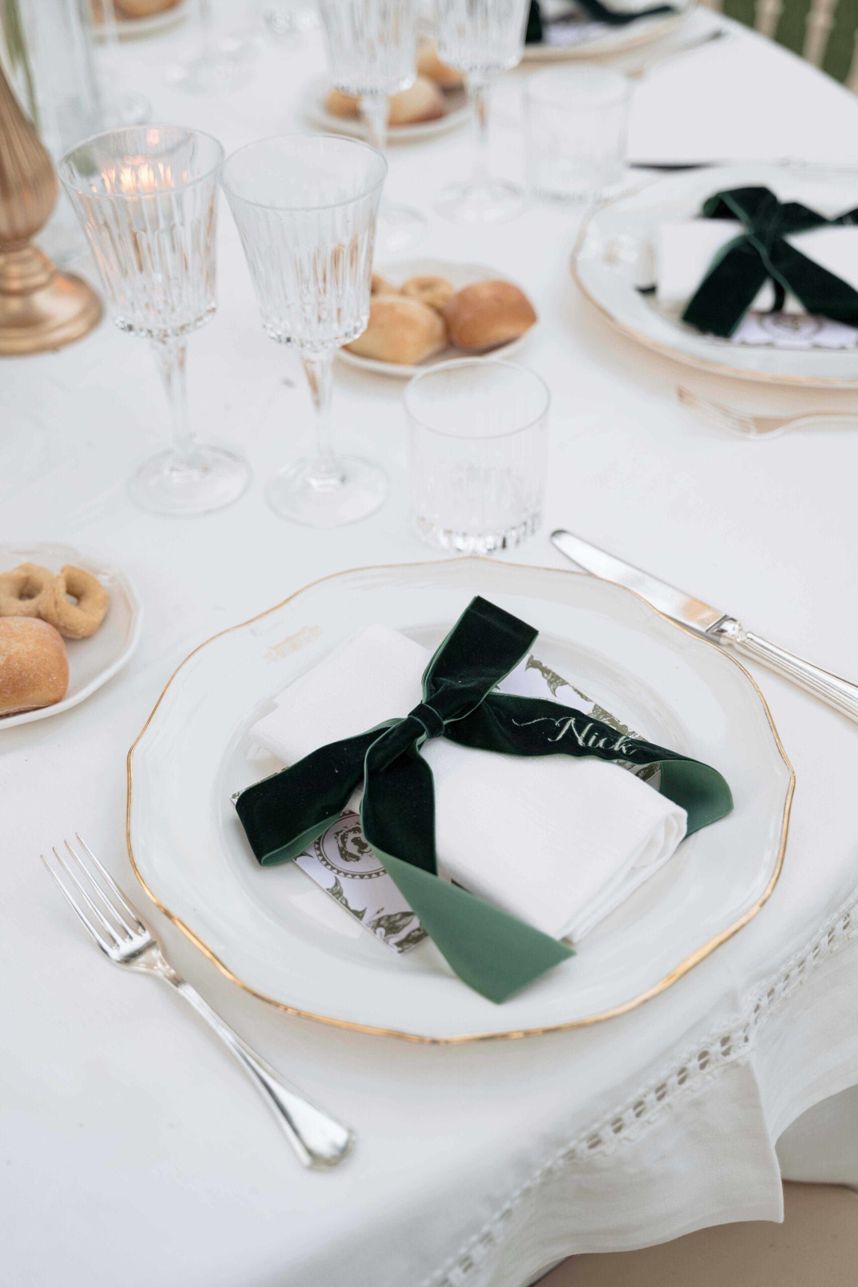A gilt-edged plate, a dark green velvet bow, taralli