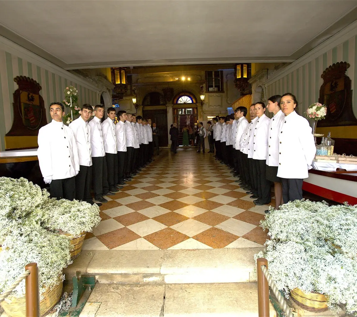 The banqueting brigade lined up along a chequerboard corridor before service
