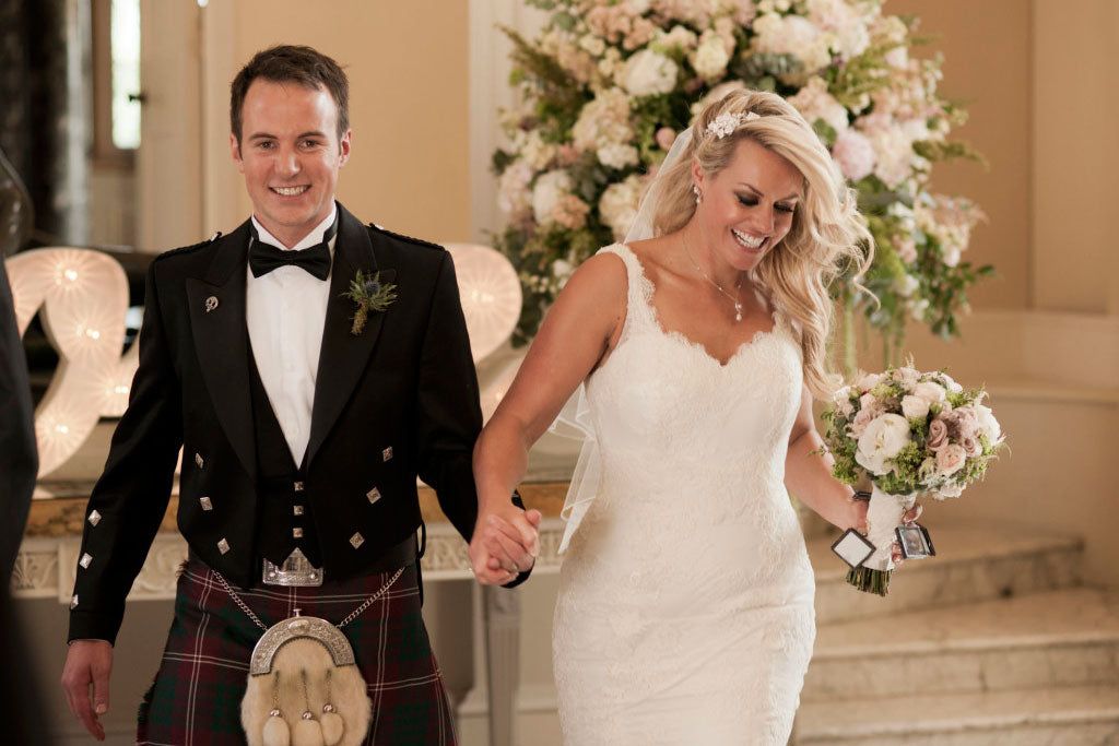 A groom in Highland dress and his bride, a real wedding