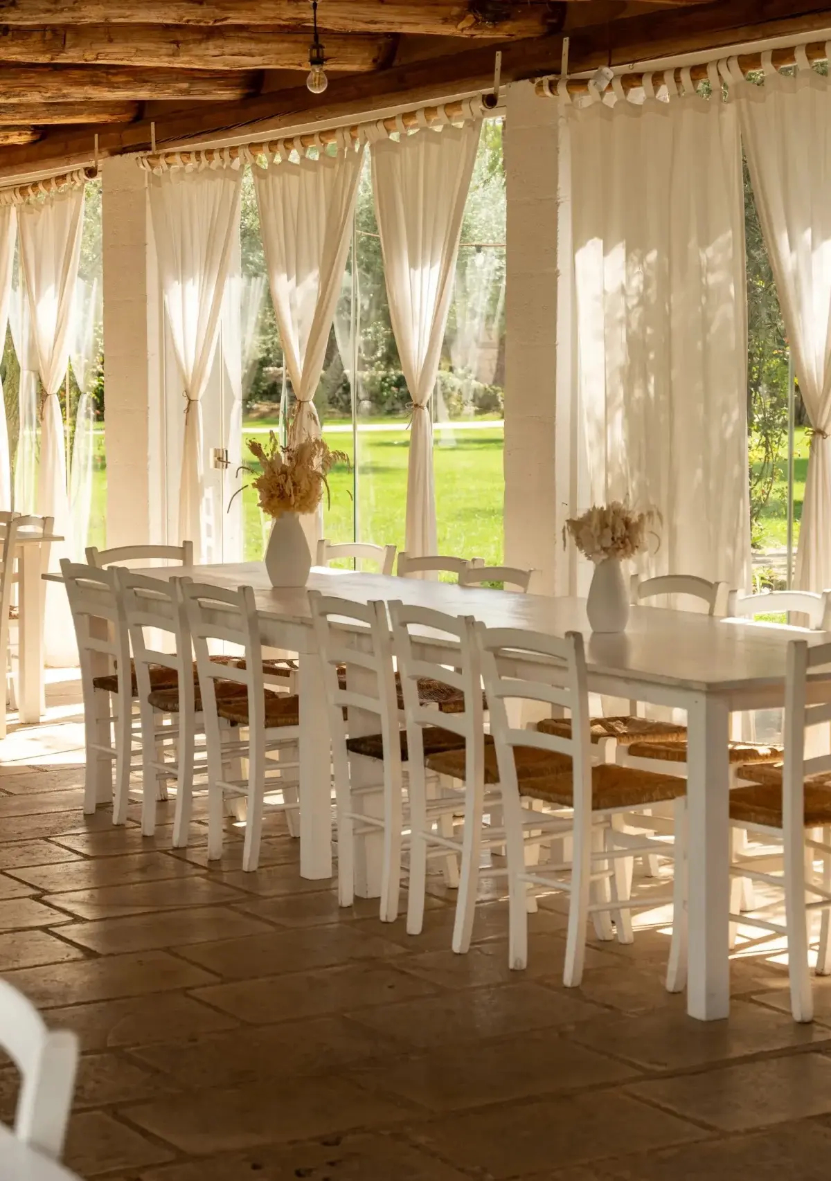 The covered dining hall with white drapes and a long table