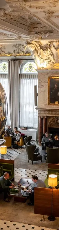 The sculptural lobby lounge, chequerboard floor beneath a silver egg sculpture, fireplace and low seating