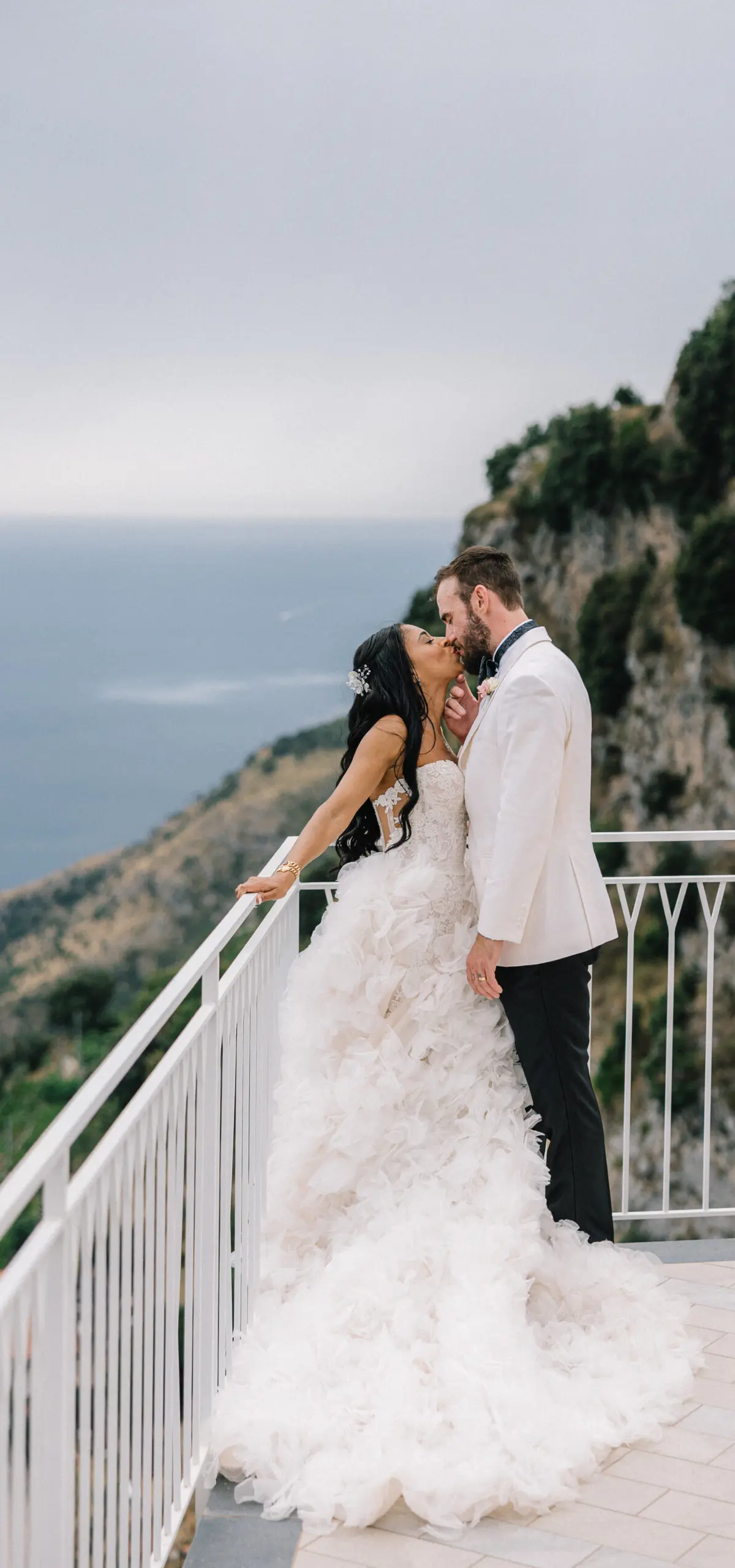 The couple on a terrace rail high above the sea on the Amalfi Coast