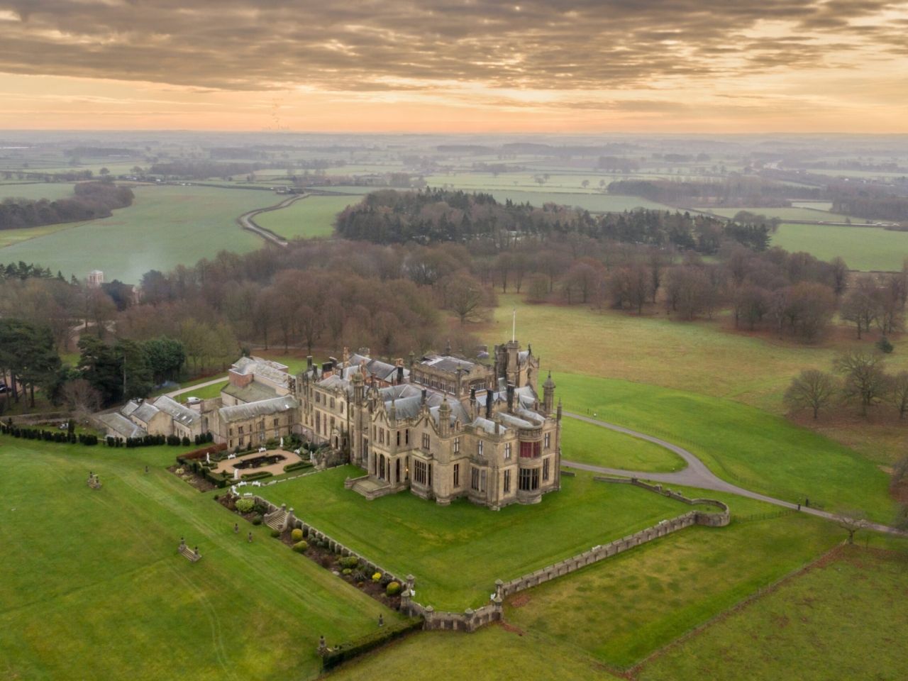 An aerial view of the castle and its estate at dusk