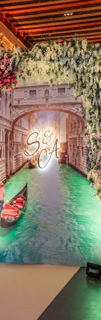 A painted Venetian canal backdrop bearing the couple's monogram, Misericordia, Venice
