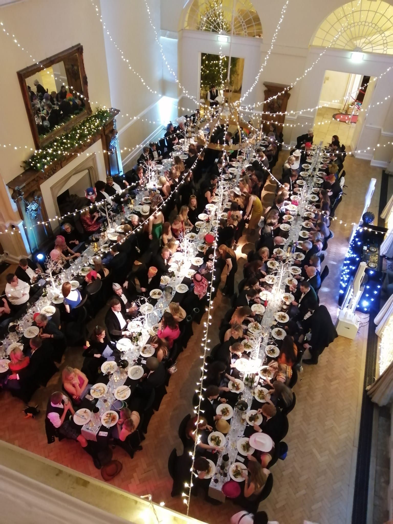 A candlelit banquet, long tables dressed for the wedding breakfast
