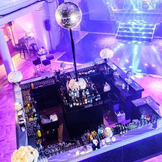 An overhead view of a black bar and mirror-ball beneath the galleries