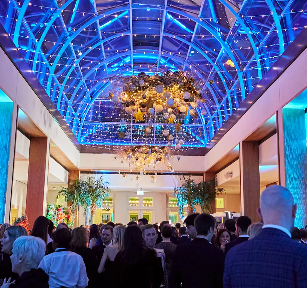 A drinks reception under the illuminated Palm Court dome