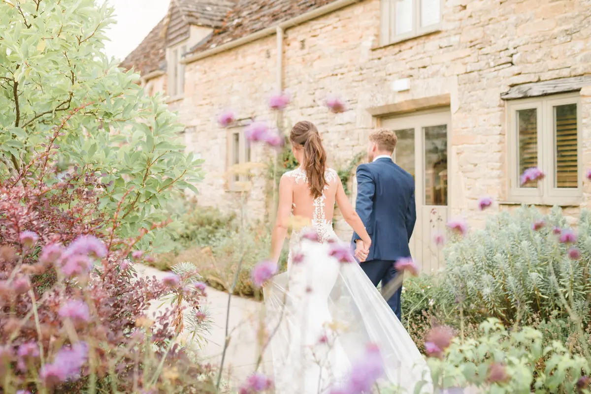 The couple walking through the gardens at Caswell House