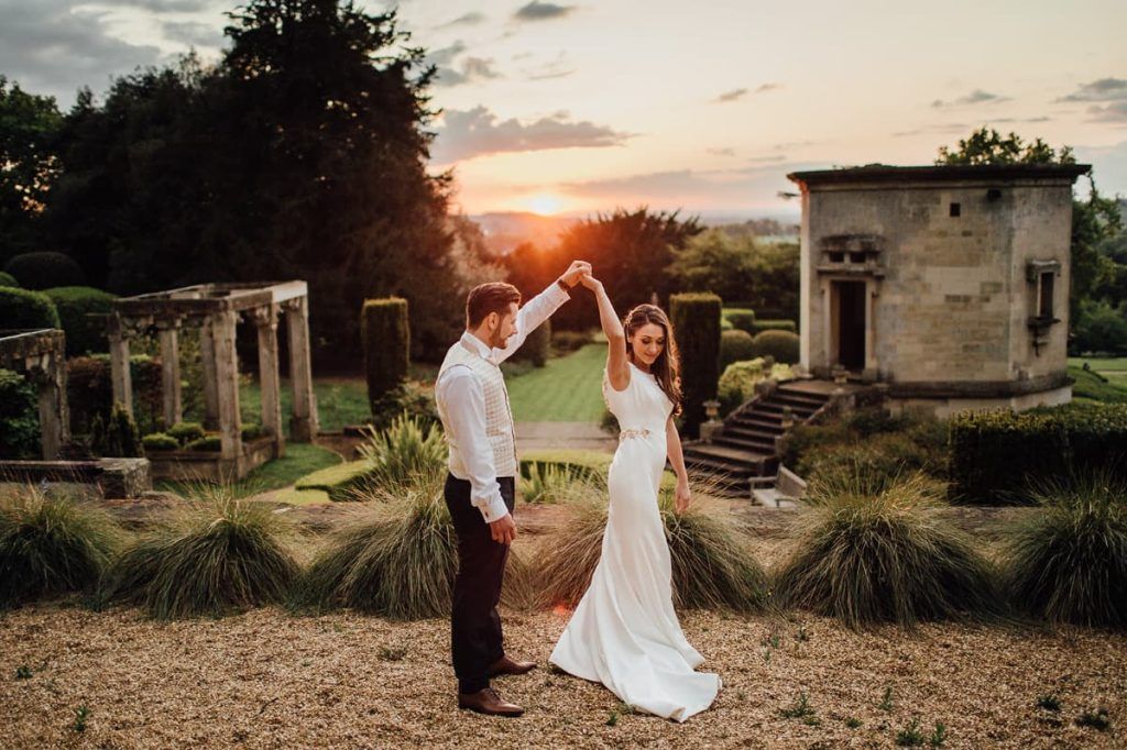 A couple dancing at golden hour beside the garden's classical ruins