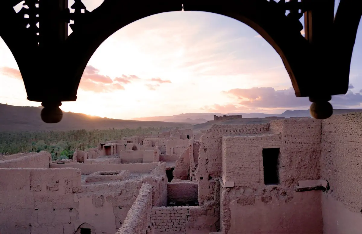The Drâa Valley at dusk, framed by a carved arch, Kasbah des Caïds, Agdz, Morocco