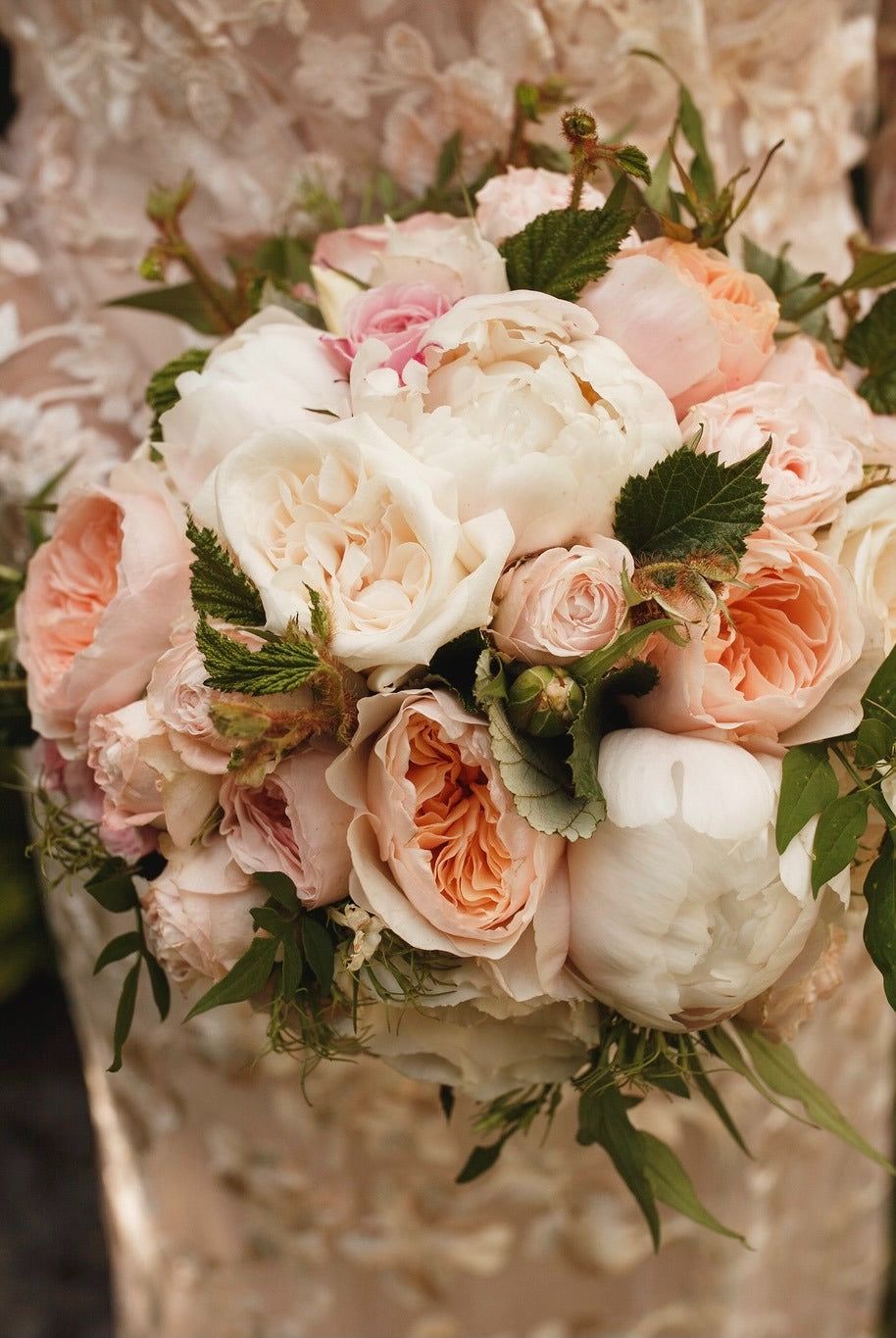 A midsummer bridal bouquet in peach, blush and ivory garden rose, Barnsley House
