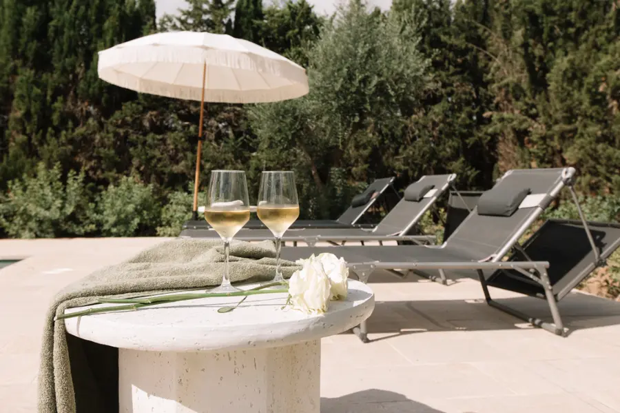 Pool terrace with sun loungers, olive trees behind