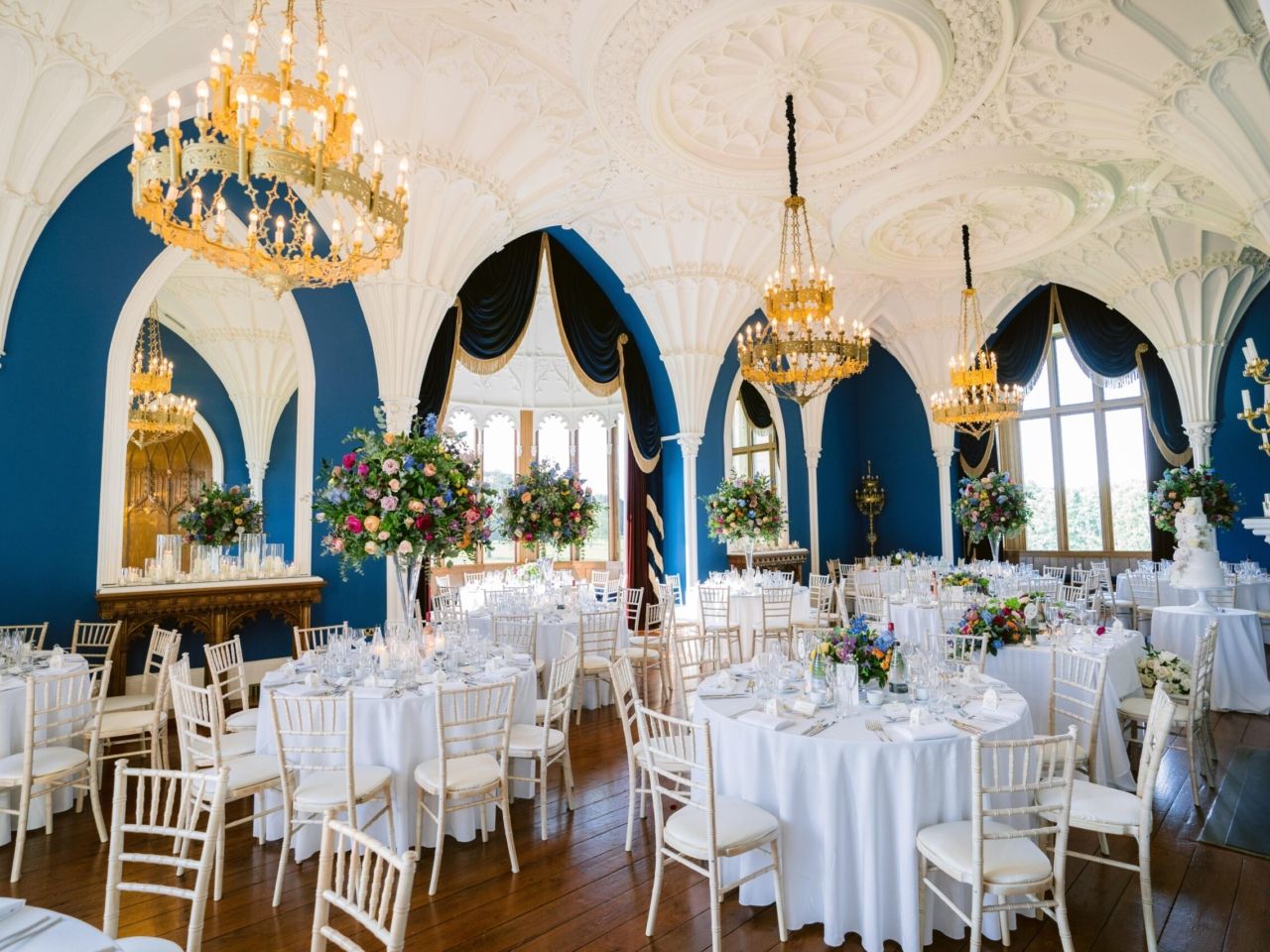 The vaulted Ballroom laid for the wedding breakfast, white linen beneath the blue Gothic arches, Allerton Castle, Knaresborough, England