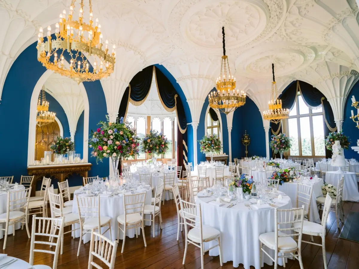 The vaulted Ballroom laid for the wedding breakfast, white linen beneath the blue Gothic arches, Allerton Castle, Knaresborough, England