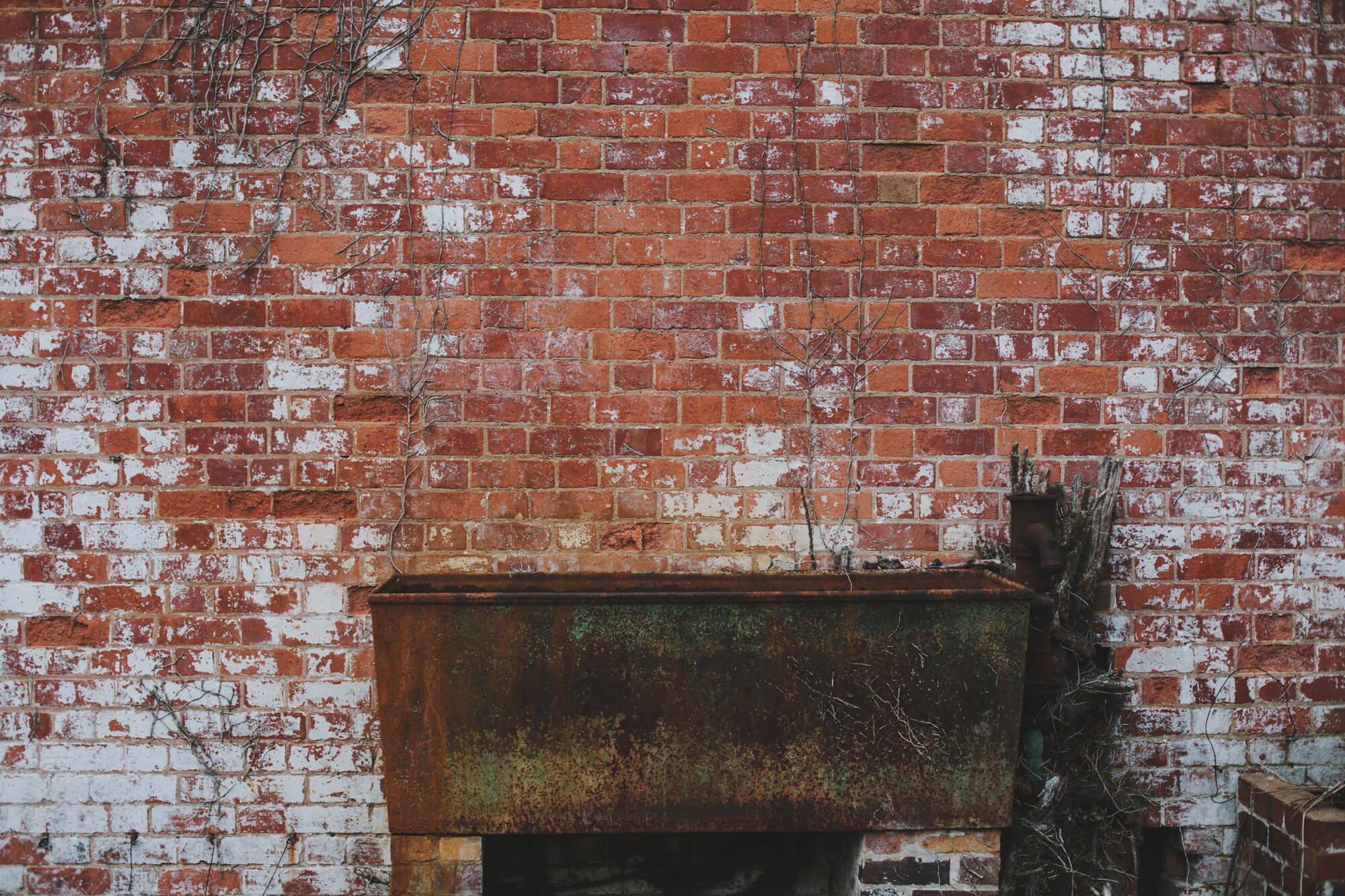 A weathered brick wall with a rustic console, the texture of the old estate buildings