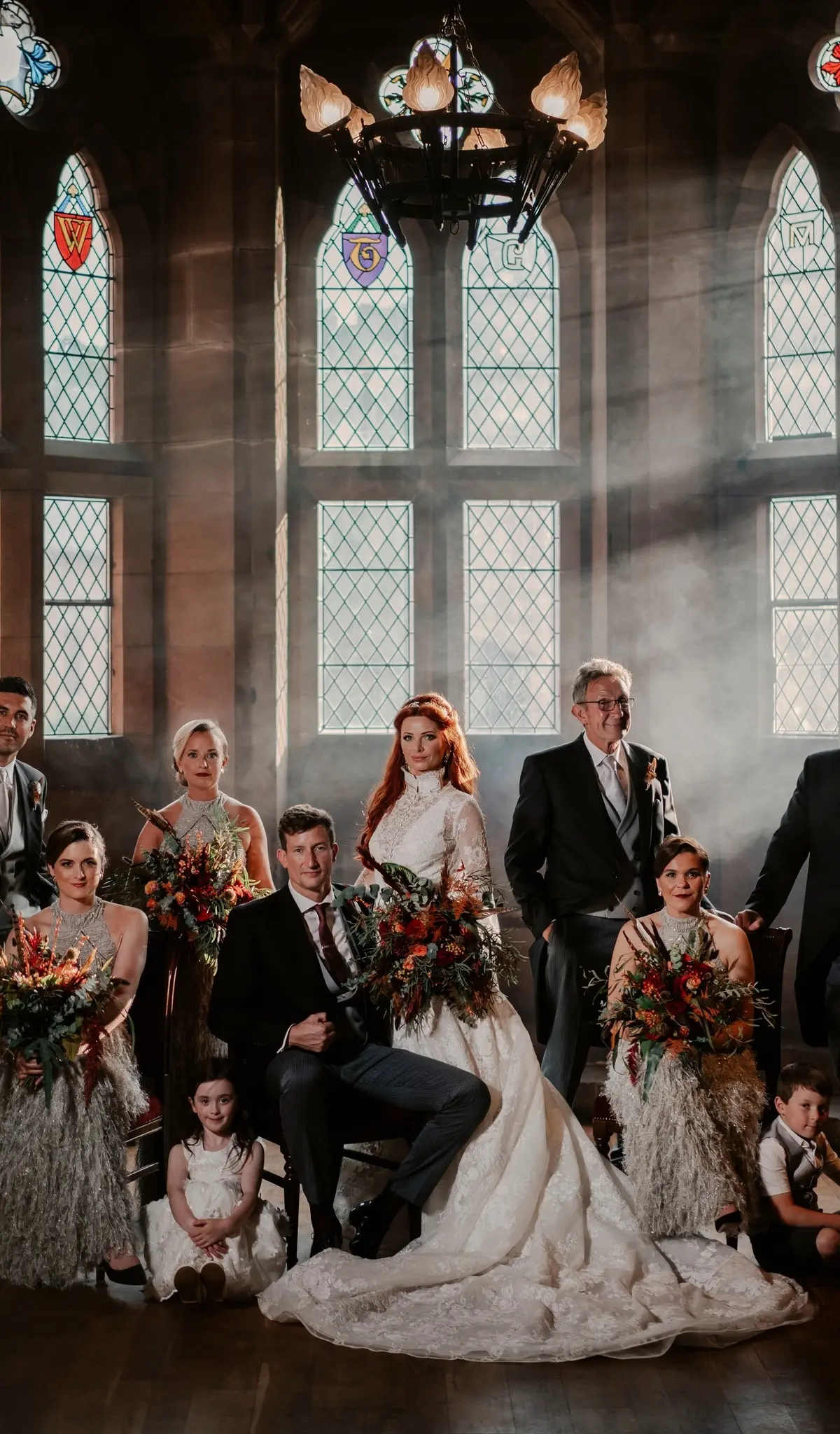 A wedding party beneath the heraldic stained-glass windows