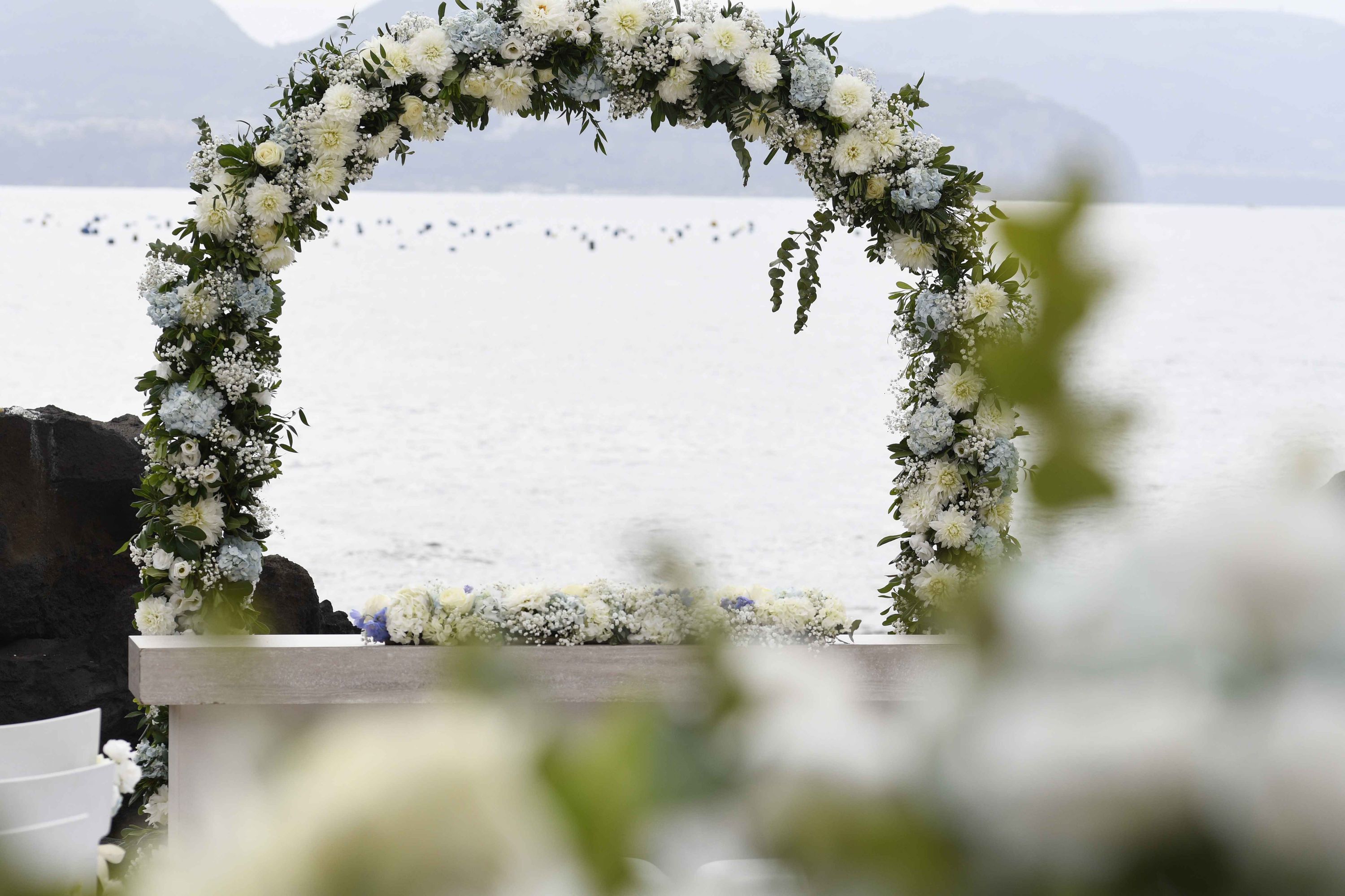 A floral arch ceremony by the shore