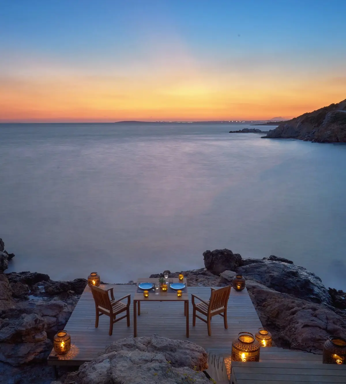 A private candlelit dinner set on the rocks at sunset, the Aegean beyond, Six Senses Kaplankaya, Milas, Turkey
