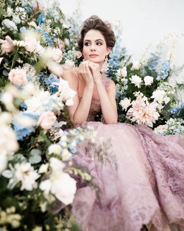 A bride, styled among blush and blue florals