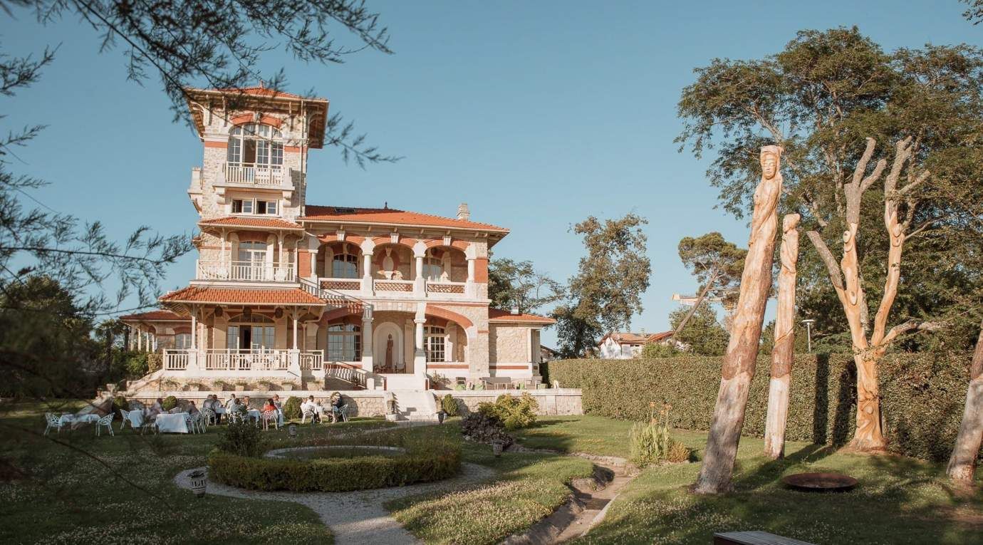 A ceremony on the lawn before a villa