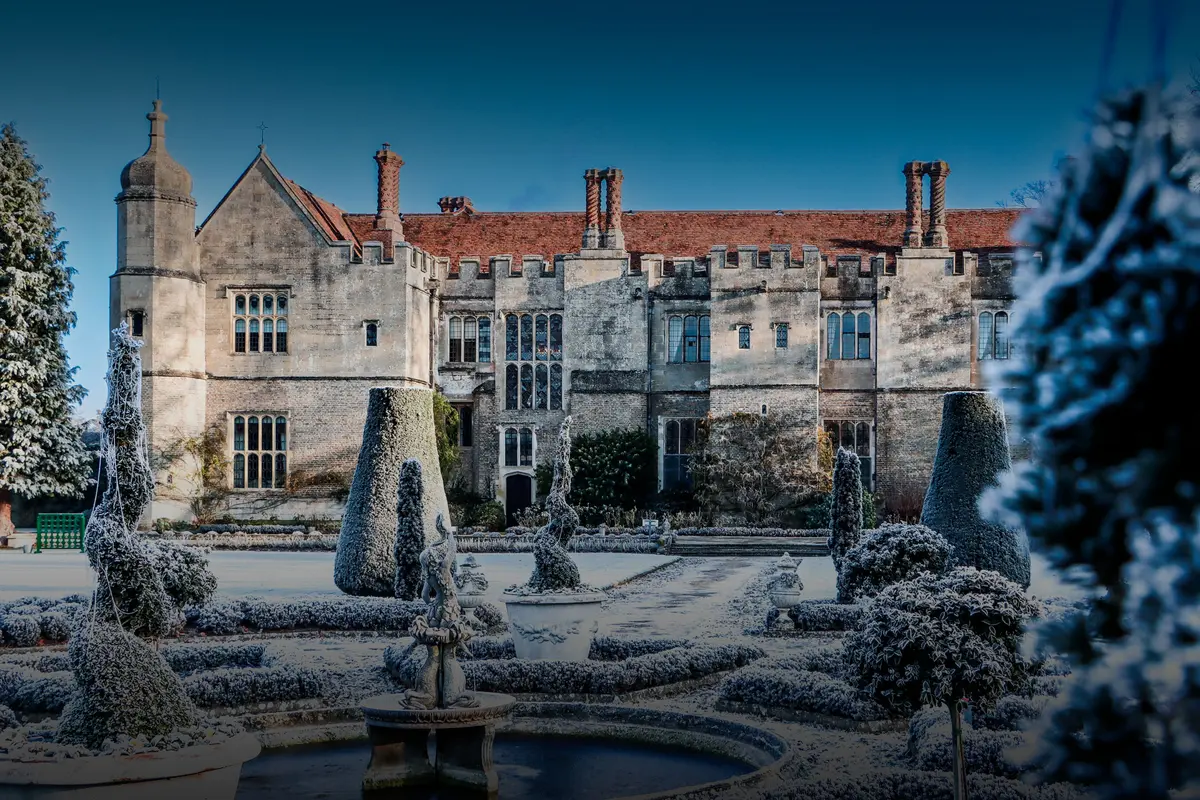 Hengrave Hall, the Tudor manor house rising beyond a clipped parterre garden and fountain, Hengrave Hall, Bury St Edmunds, England