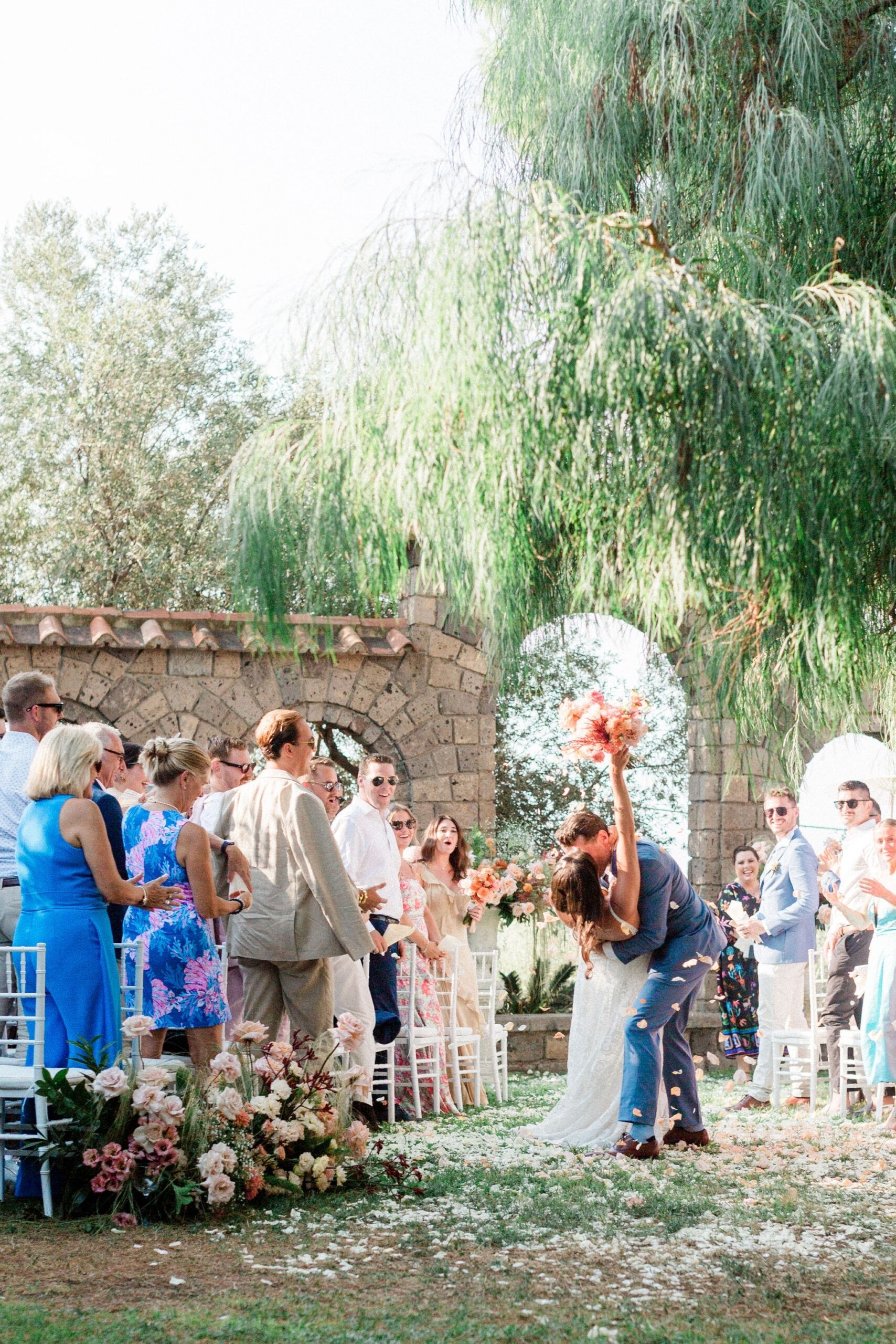 A recessional under a stone archway and a weeping willow