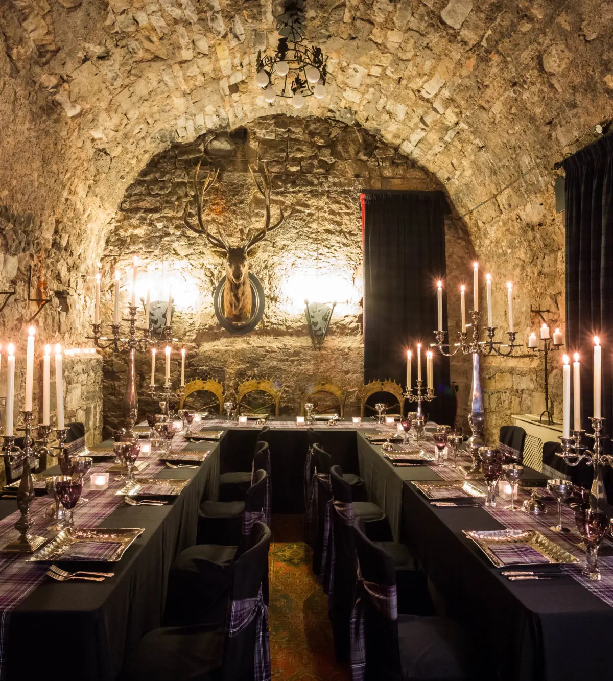 The Stag Chamber laid for a candlelit feast beneath vaulted stone