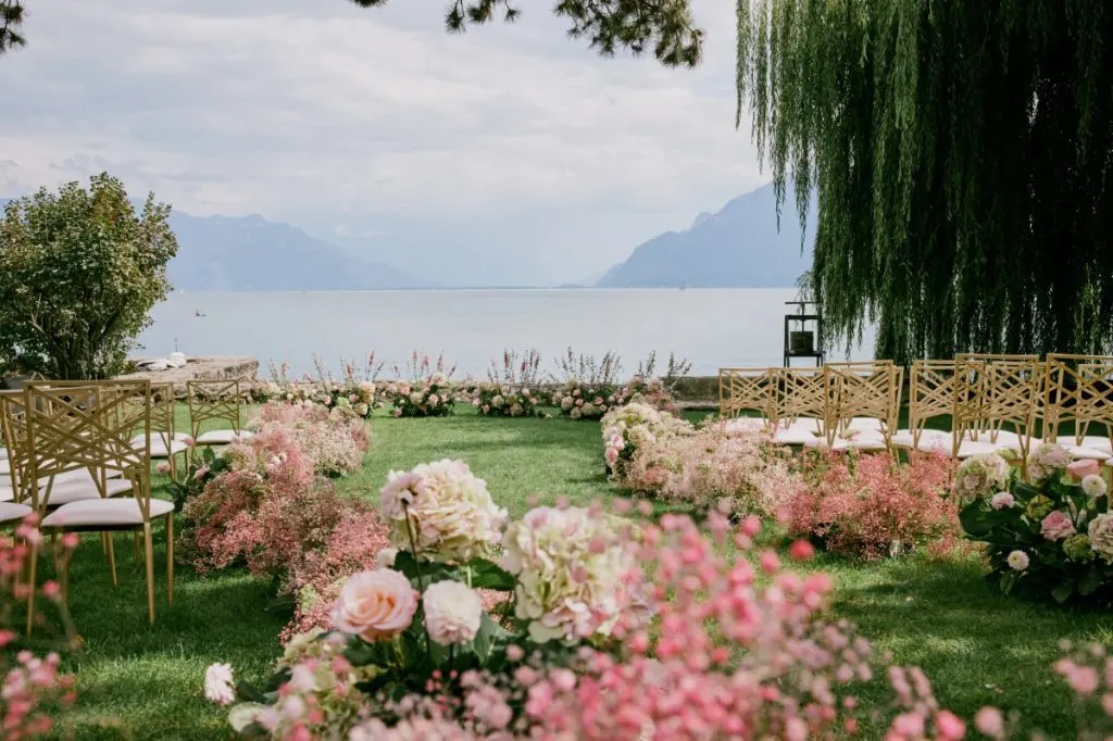 An aisle banked in pink and white, above the water