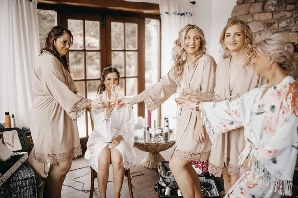 Bridesmaids in matching robes toast as the bride's hair is finished, Loxus Hair and Makeup, Cardiff, Wales