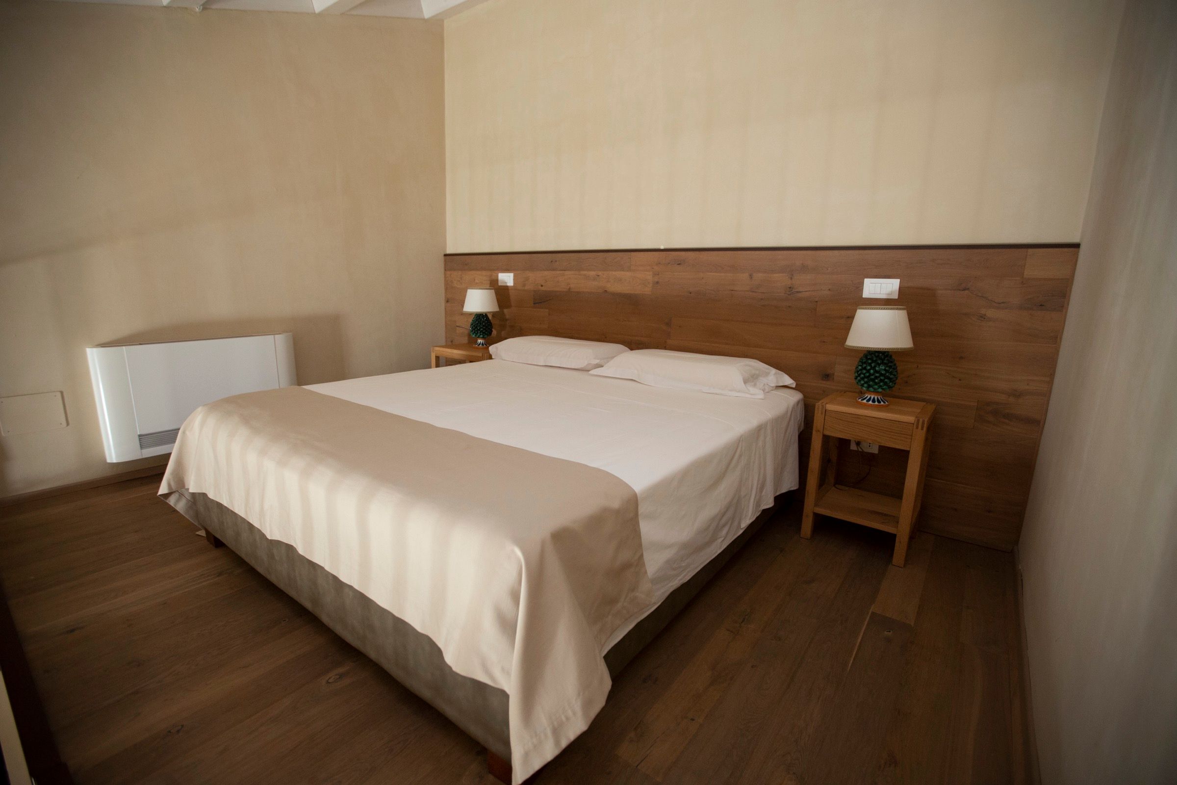 A Superior room, dark wood headboard against pale walls