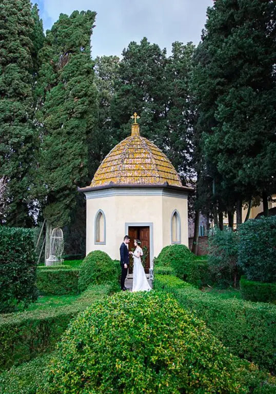 Couple by the private chapel in the Italian garden at Borgo Bucciano