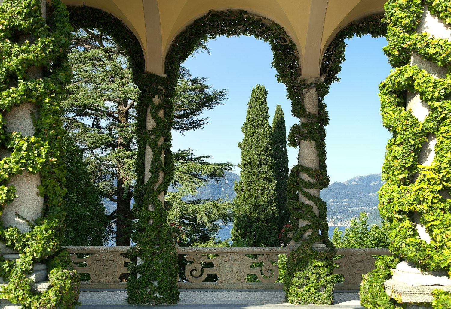 The ivy-clad Loggia Durini with its arches framing cypress and the lake, Villa del Balbianello