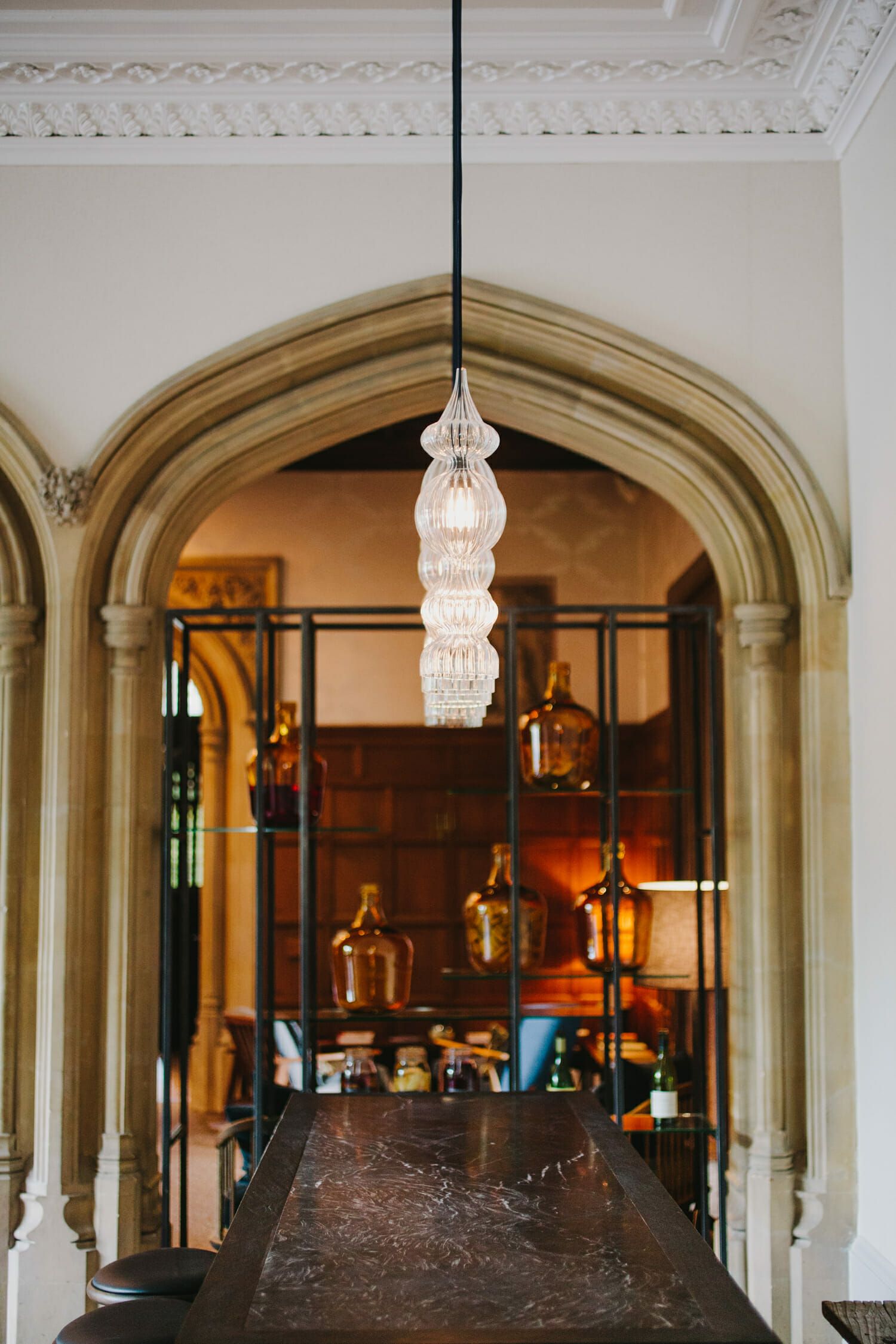 A vaulted interior hallway, a glass lantern hanging beneath the pointed arch