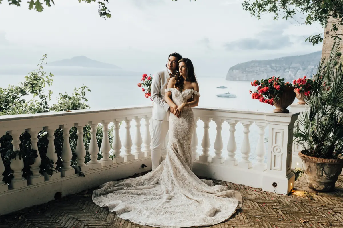 An embrace on a white balustraded terrace, Vesuvius across the Bay of Naples