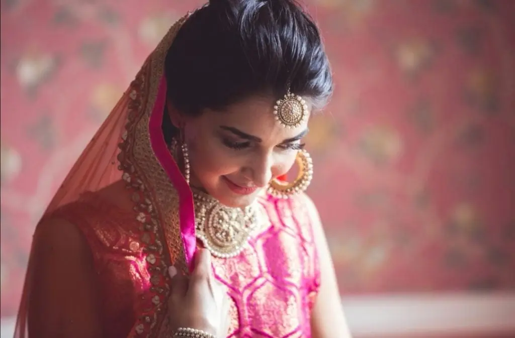 An Indian bride's pink and gold lehenga, layered pearl jewellery, close portrait, Wedding Hair And Makeup By Lisa, Southampton, England